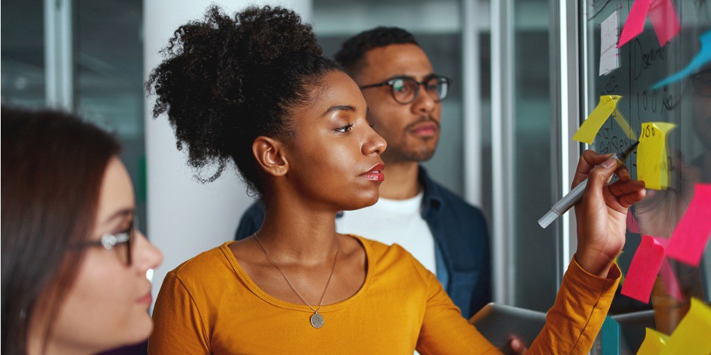 young-creative-businesswoman-standing-with-her-colleagues-writing-new-picture-id1171916653 colleagues learning and brainstorming