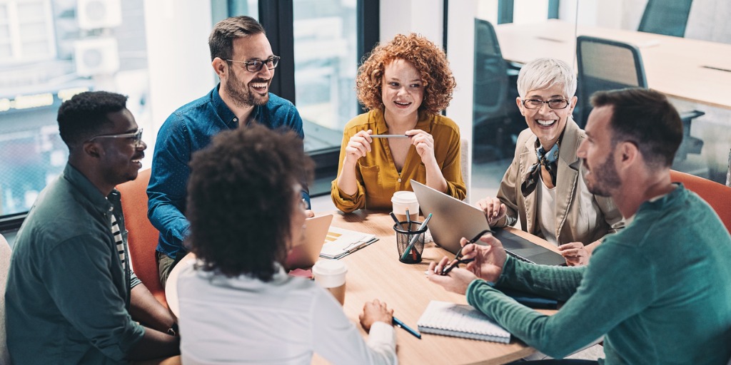 mixed-group-of-business-people-sitting-around-a-table-and-talking-picture-id1392016982 Creativity involves looking at tasks and situations through a new lens, using imagination backed up by experience to generate new ideas.