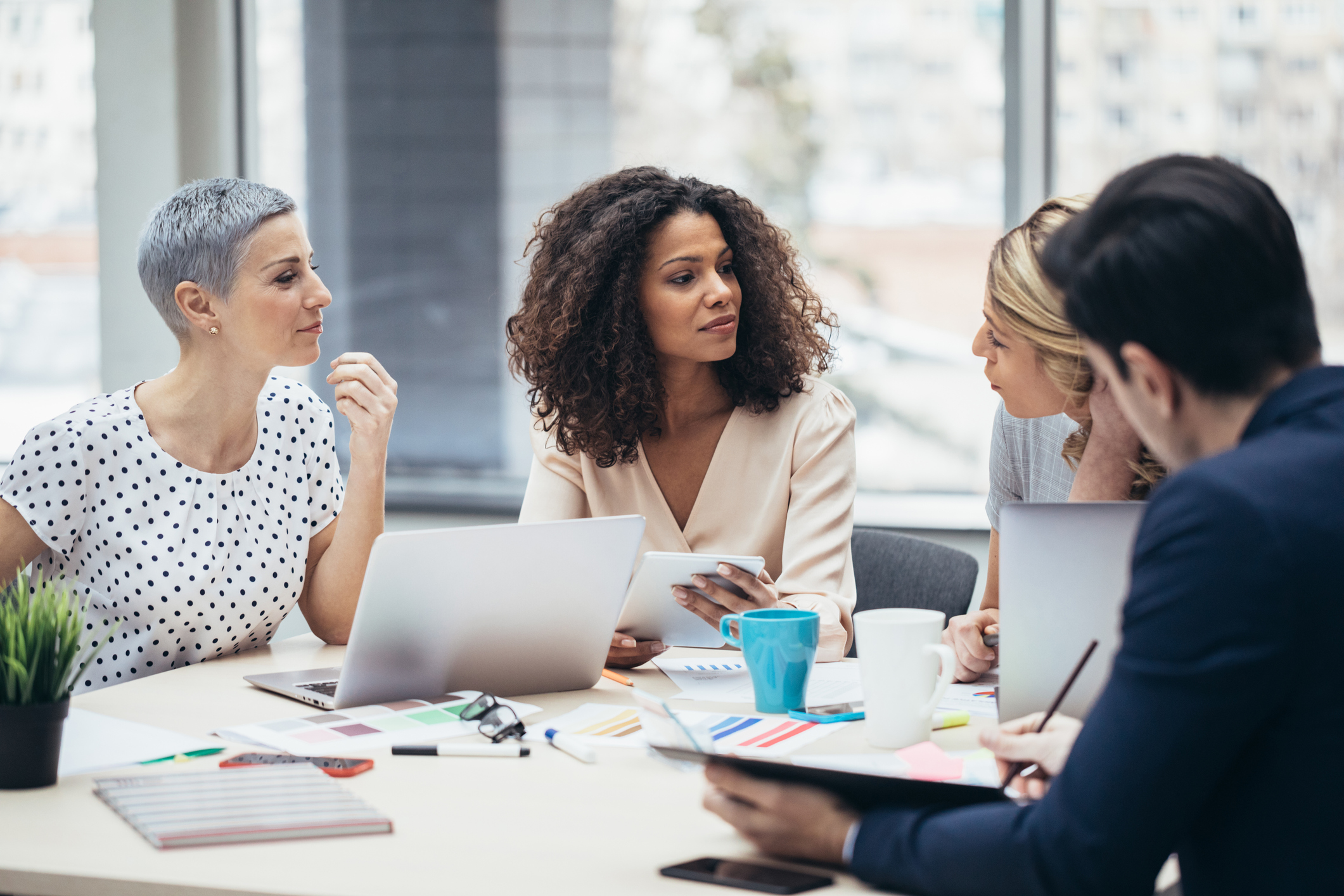 Professionals gathered around a table discussing. 