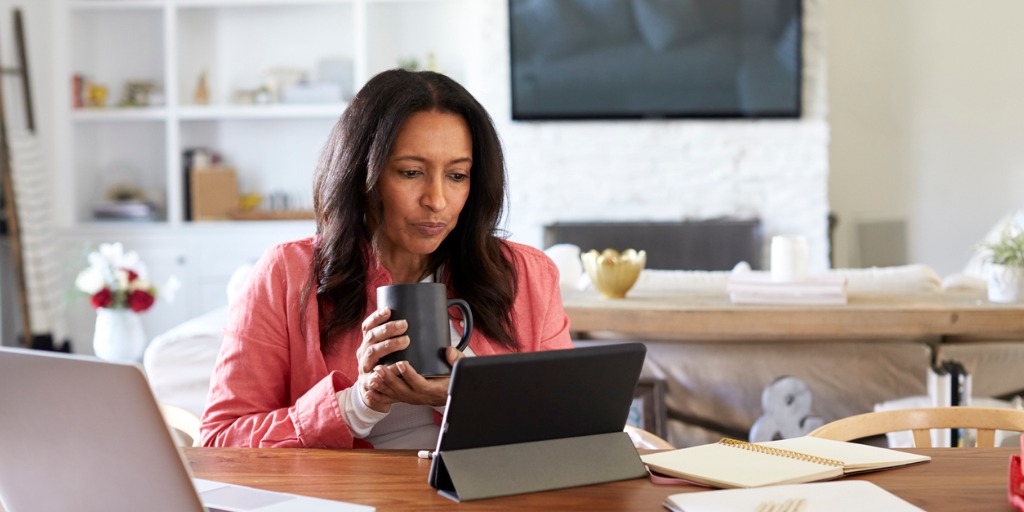 middle-aged-woman-sitting-at-a-table-reading-using-a-tablet-computer-picture-id1126141028 remote working is one of the stronger trends to emerge from 2020