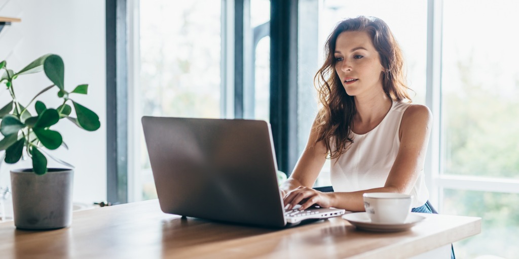 woman-using-laptop-while-sitting-at-home-picture-id1212597557